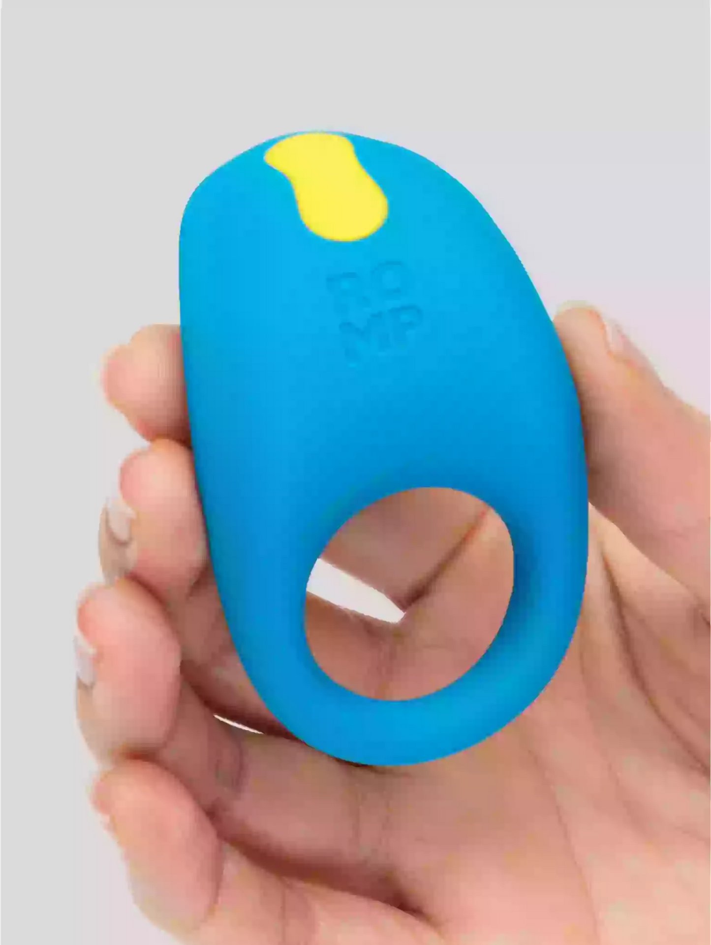 Blue and yellow device held in a hand against a gray background