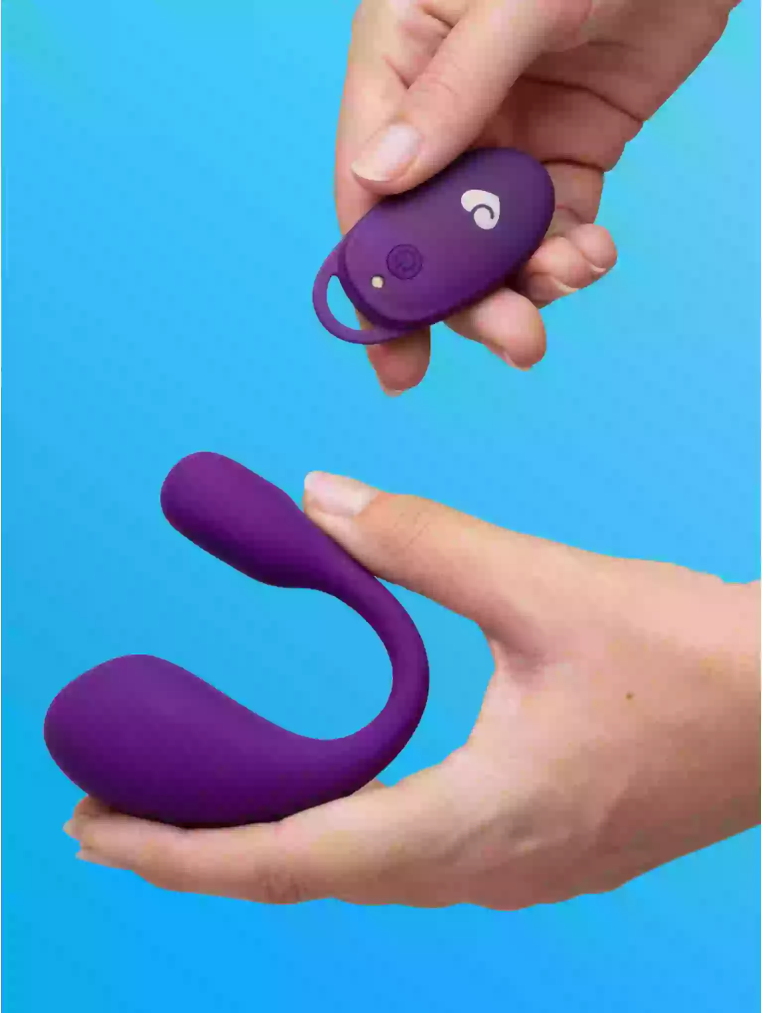 Purple silicone product with remote control held by hands against a blue background