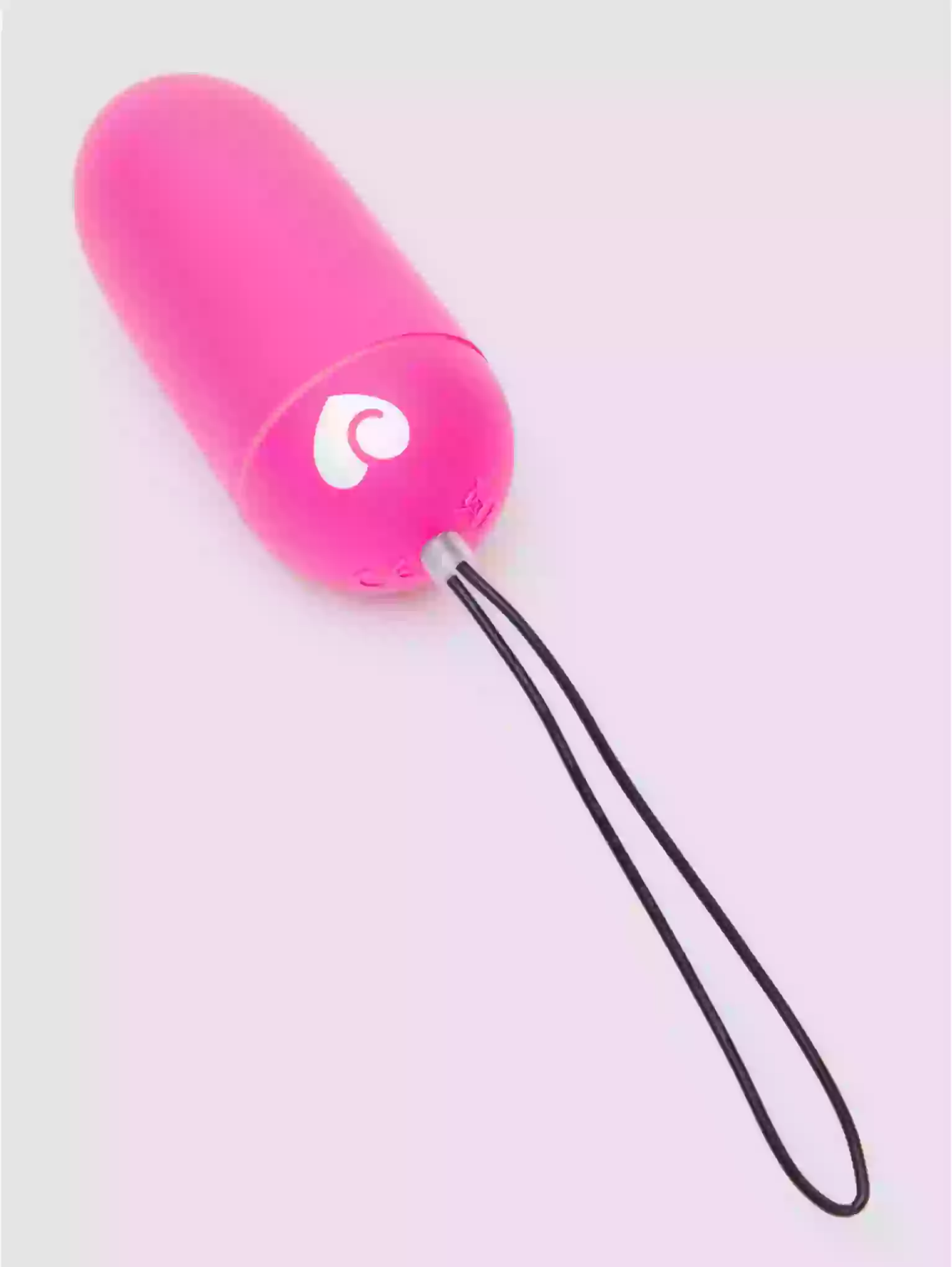 Pink object with a black string on a light pink background
