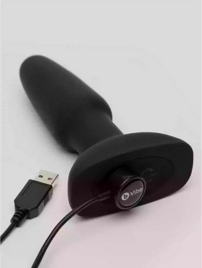 Black electronic device with USB cable on a light gray background