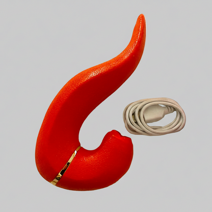 Red curved object with gold accent and white cable on gray background