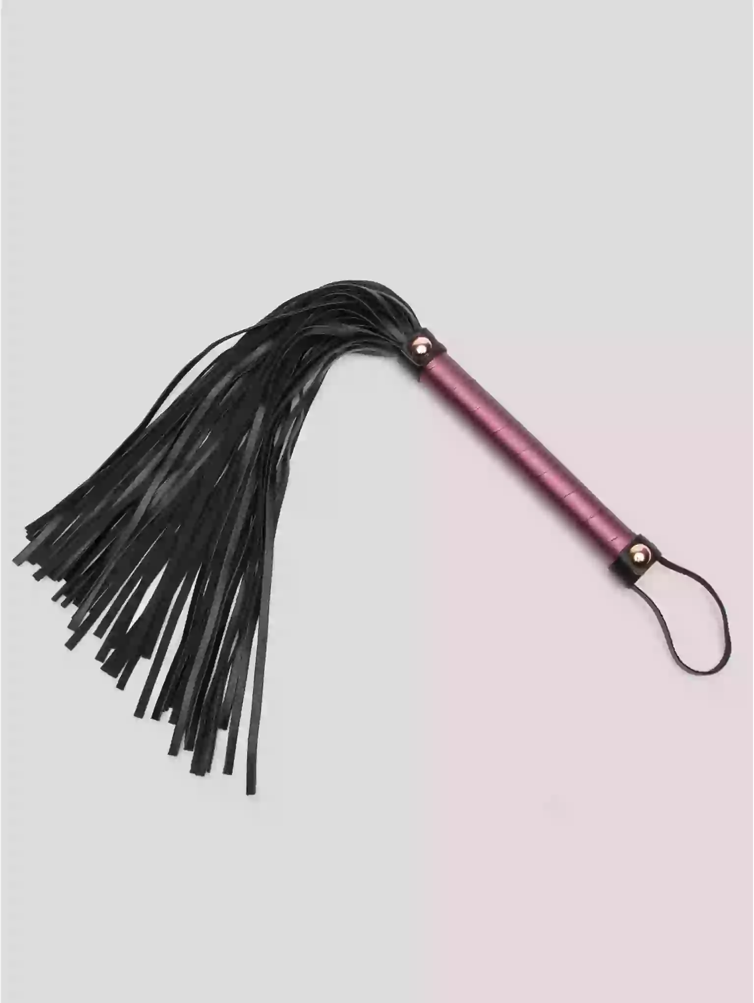 Black leather flogger with pink handle on a light gray background