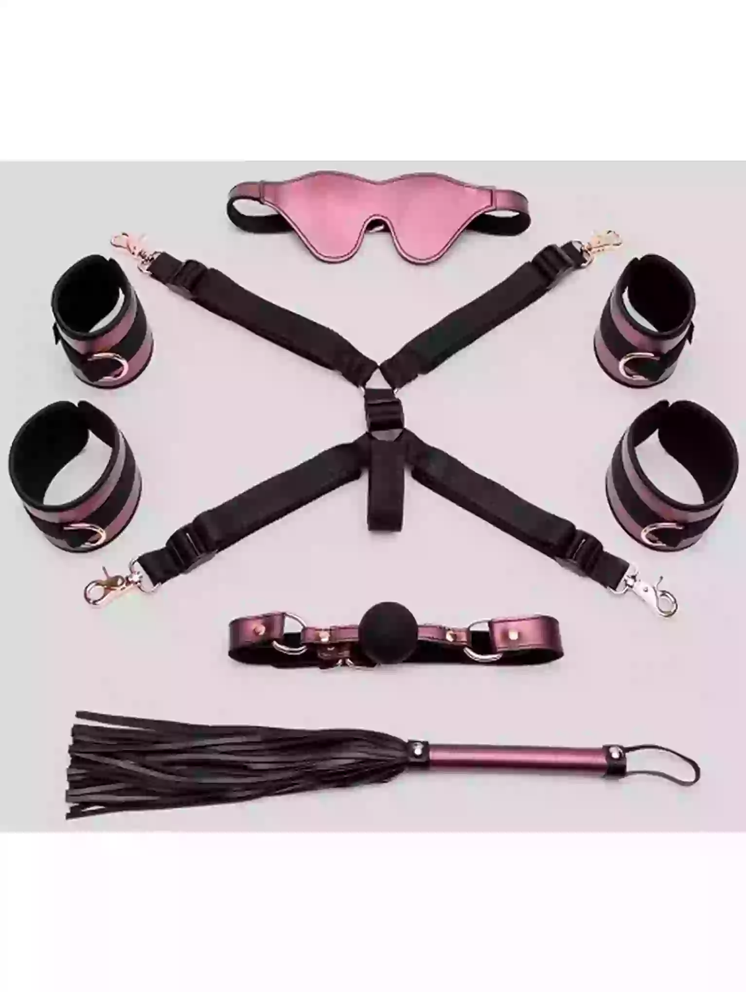 Collection of bondage accessories including a blindfold, handcuffs, a gag, and a flogger on a light pink background.