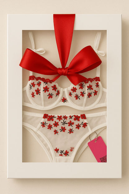 Lingerie set with red floral patterns in a white box with a red ribbon and tag.
