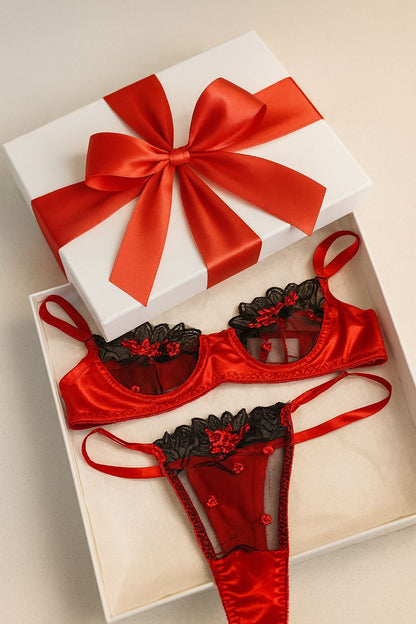 Red lingerie set with black lace details in a white box with a red ribbon.
