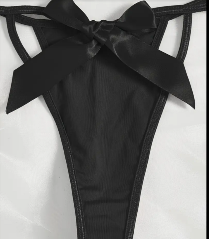 Black satin bow detail on a garment against a white background