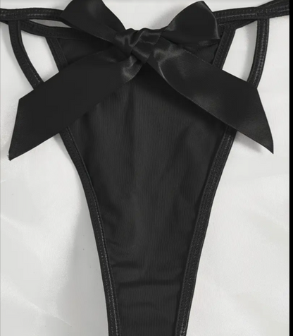 Black satin bow detail on a garment against a white background