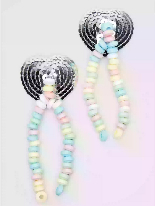 Pair of earrings with pastel beads and sequin hearts on a light background