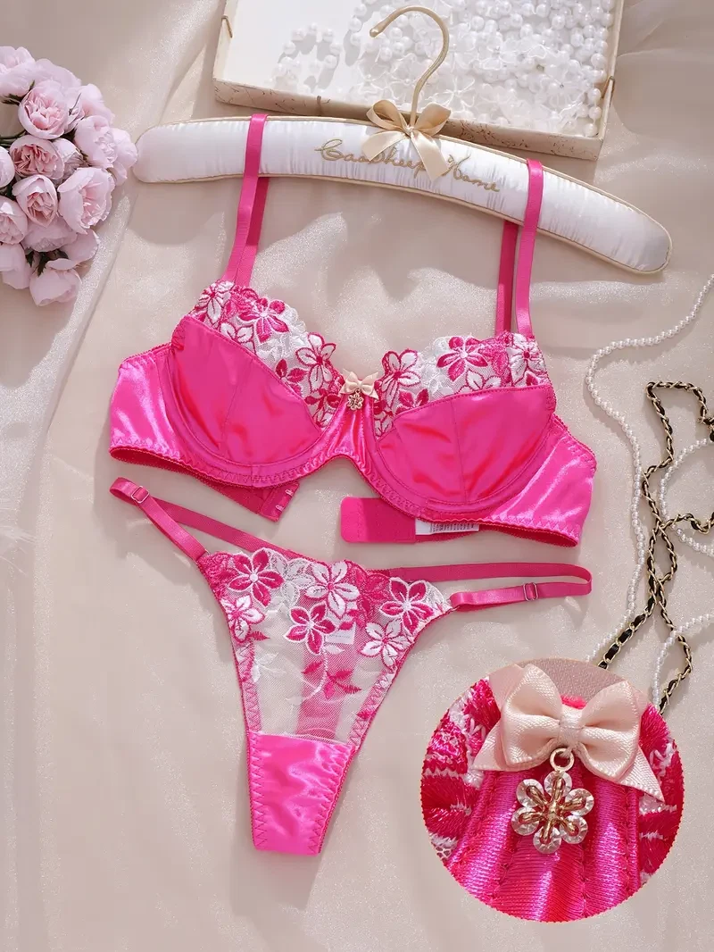 Pink floral bikini set on a hanger with decorative elements.
