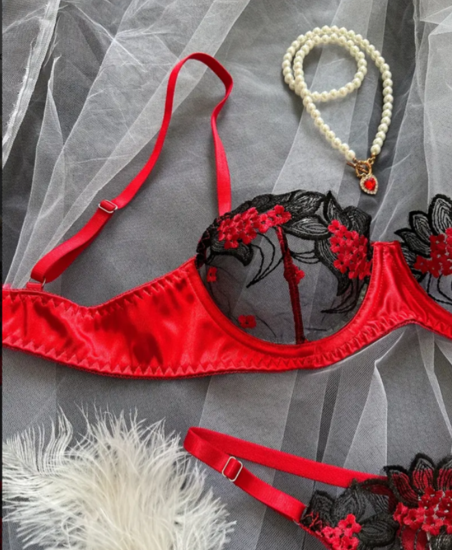 Red and black lingerie set with floral details on a gray background
