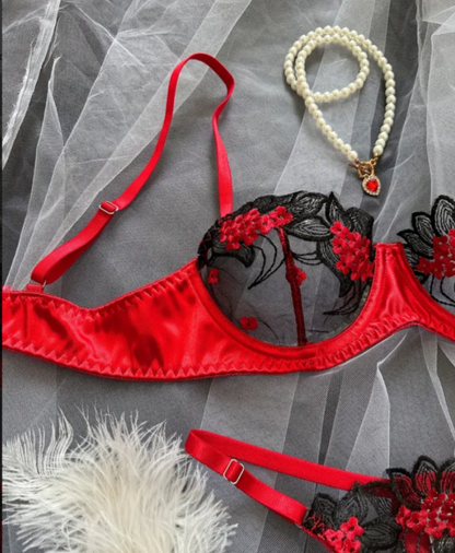 Red and black lingerie set with floral details on a gray background