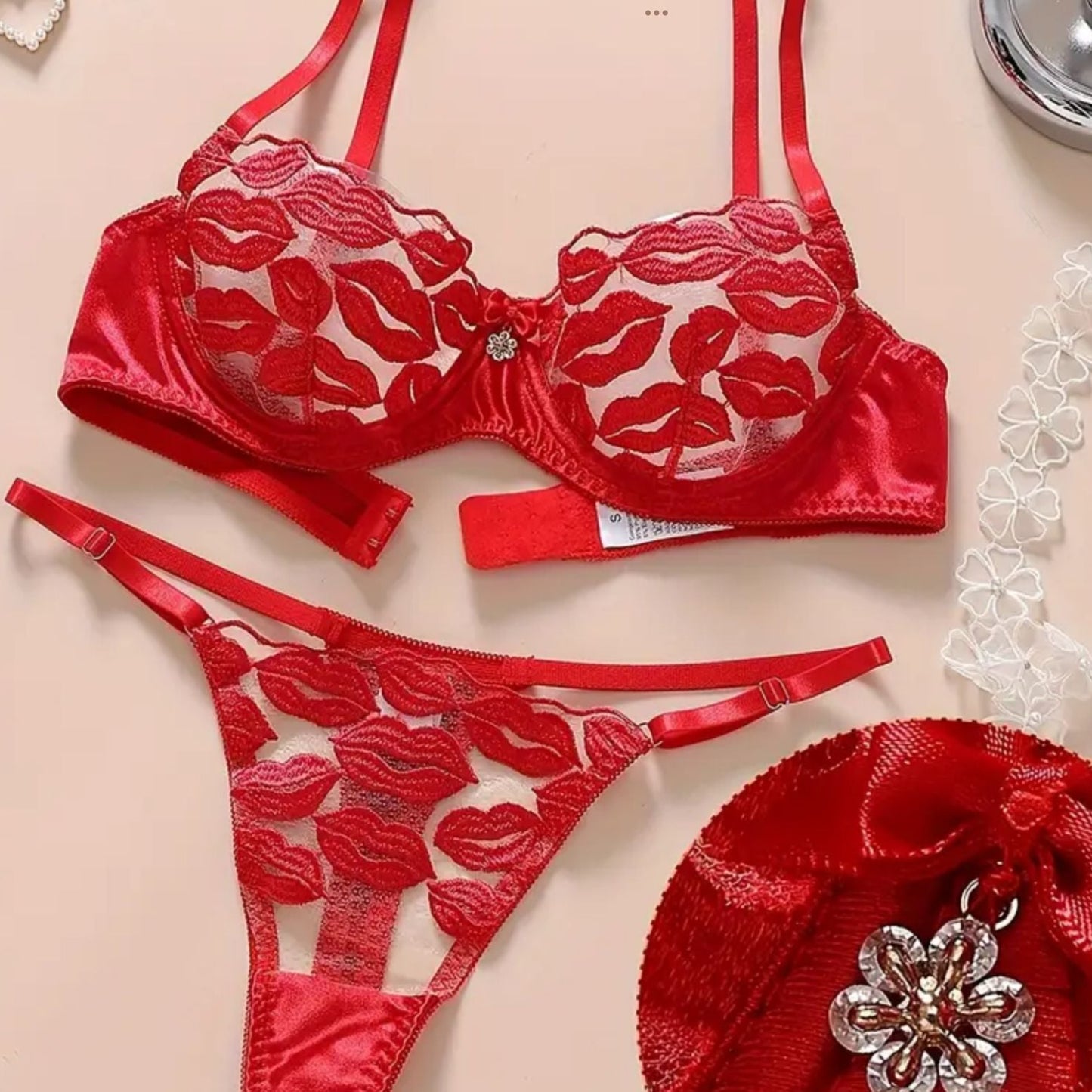 Red lingerie set with floral lace details on a beige background