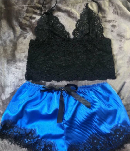 Black lace top and blue shorts set on a textured surface