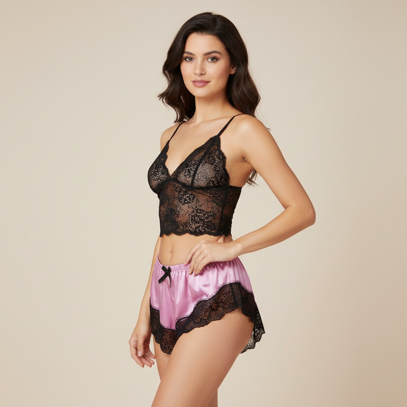 Woman wearing a black lace lingerie set with pink shorts on a beige background