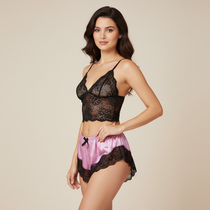 Woman wearing a black lace lingerie set with pink shorts on a beige background
