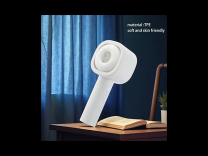 White handheld device on a wooden table with an open book and plant, against a blue curtain background.