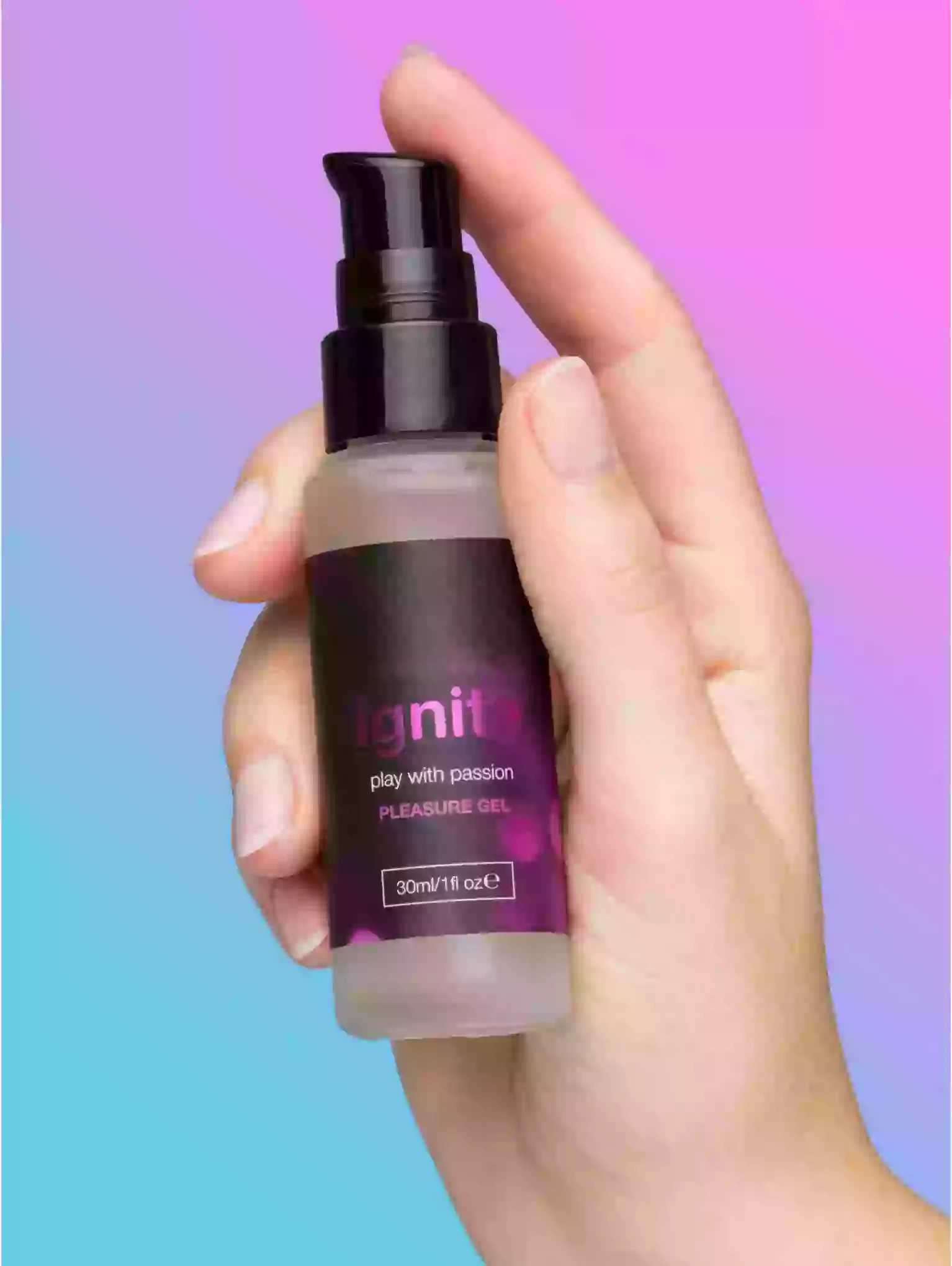 Hand holding a bottle of 'Ignite' pleasure gel against a gradient background
