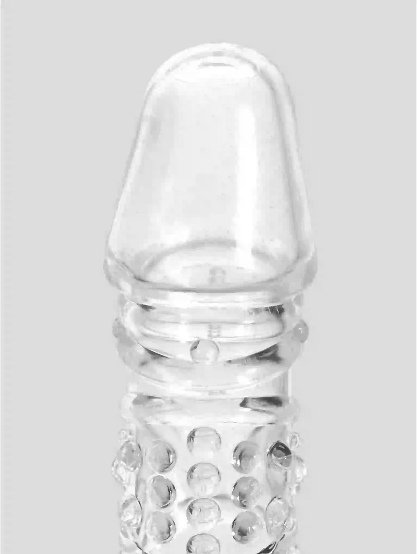 Clear glass bottle with textured base on a light gray background
