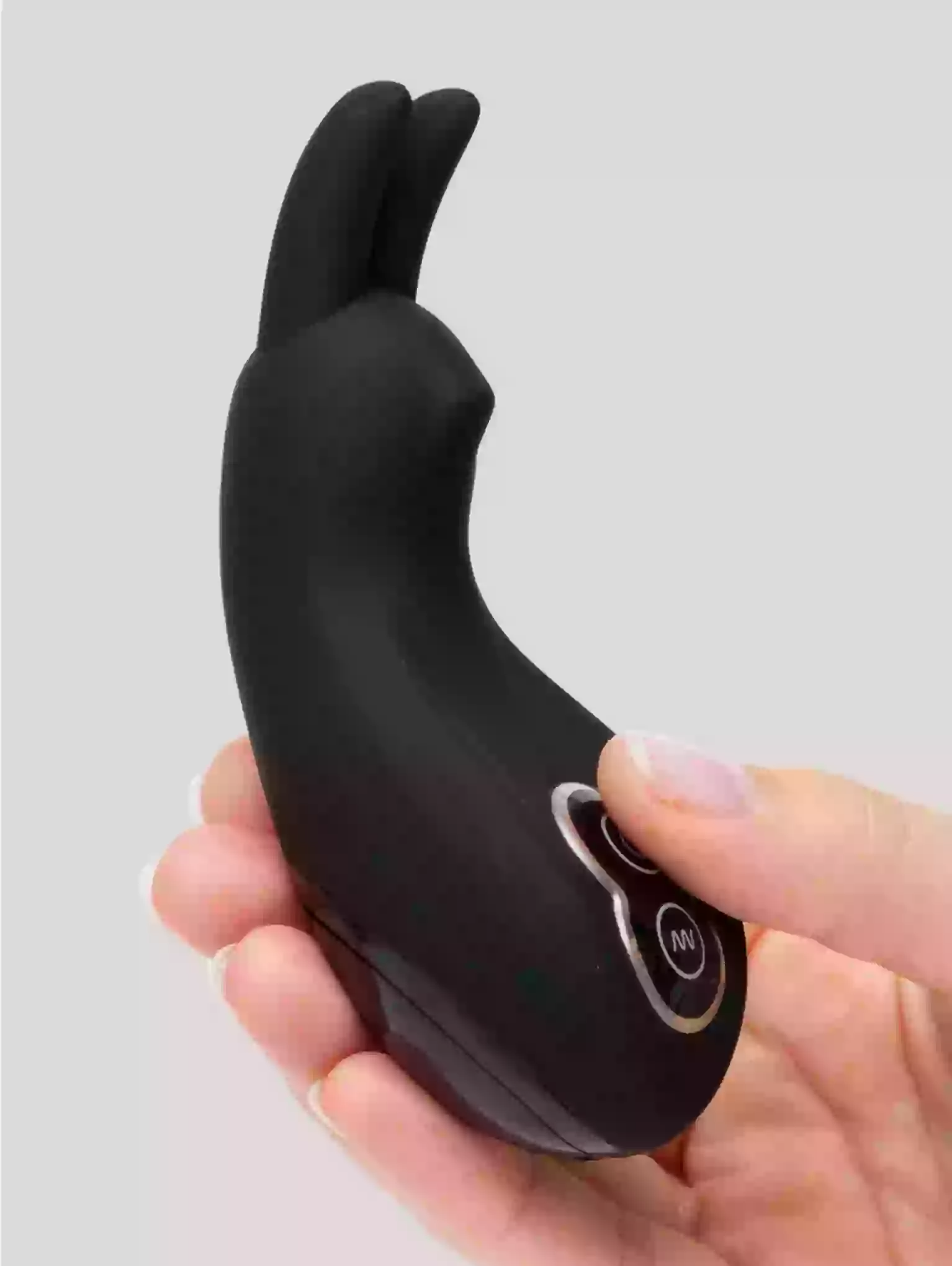 Black handheld device held in a hand against a gray background