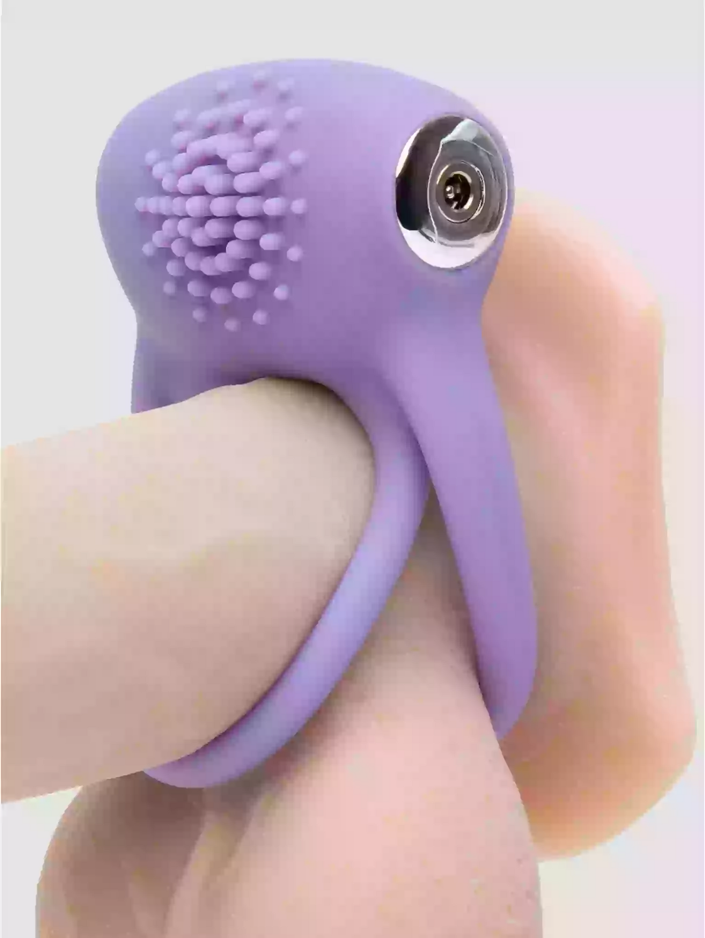 Purple silicone ring with textured top and metallic component on a neutral background