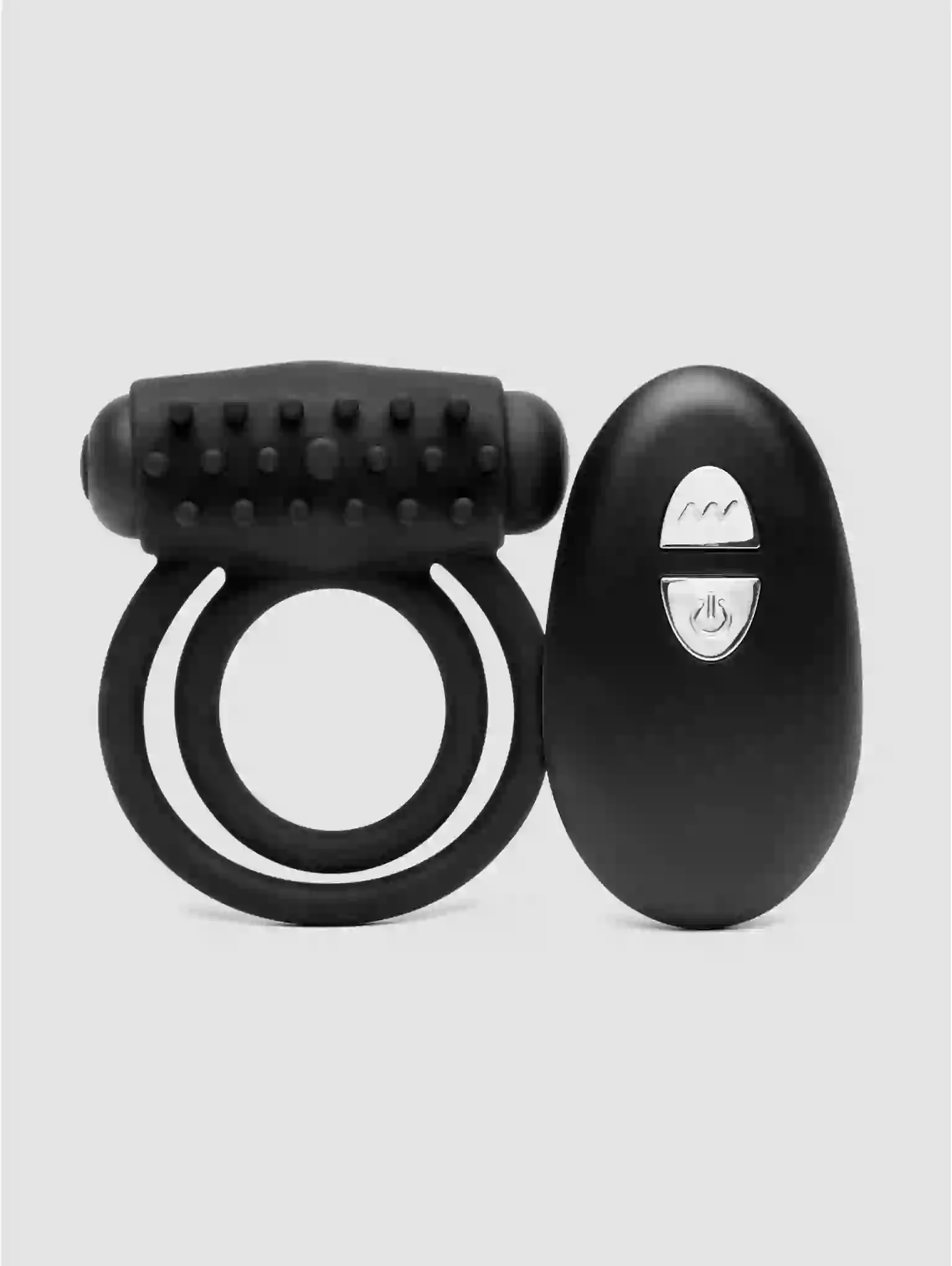 Black ring and remote control device on a light gray background