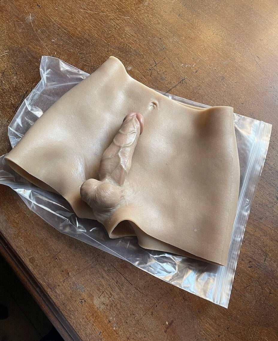 Clay sculpture of a hand on clear plastic wrap on a wooden surface