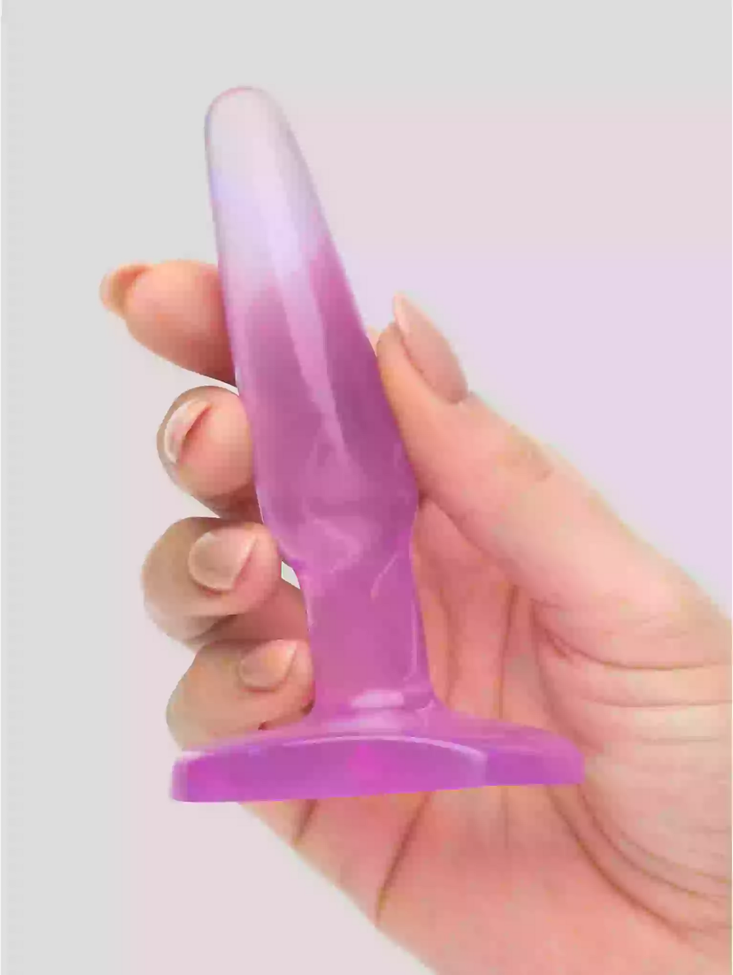 Hand holding a purple and pink gradient object against a light gray background