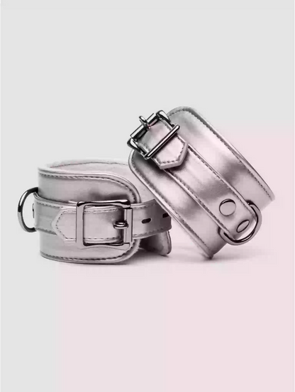Two metallic silver dog collars on a light pink background