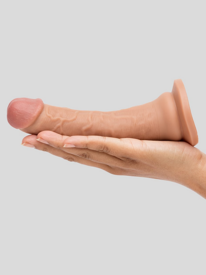 Hand holding a small brown object against a light gray background