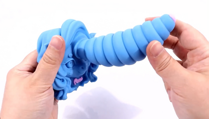 Blue dog toy with textured surface held by hands against a white background