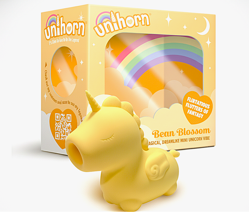 Yellow unicorn-shaped product with packaging featuring rainbow designs on a white background