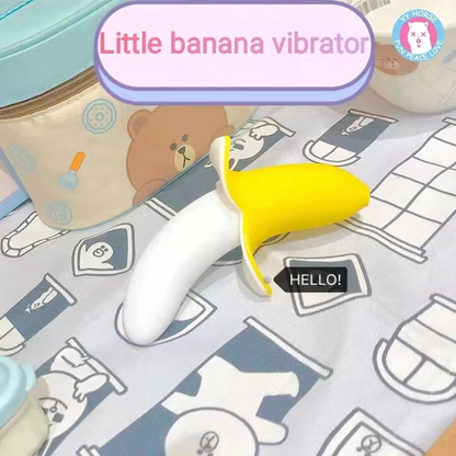 Yellow and white toy labeled 'Little banana vibrator' on a patterned surface with cartoon bear design.