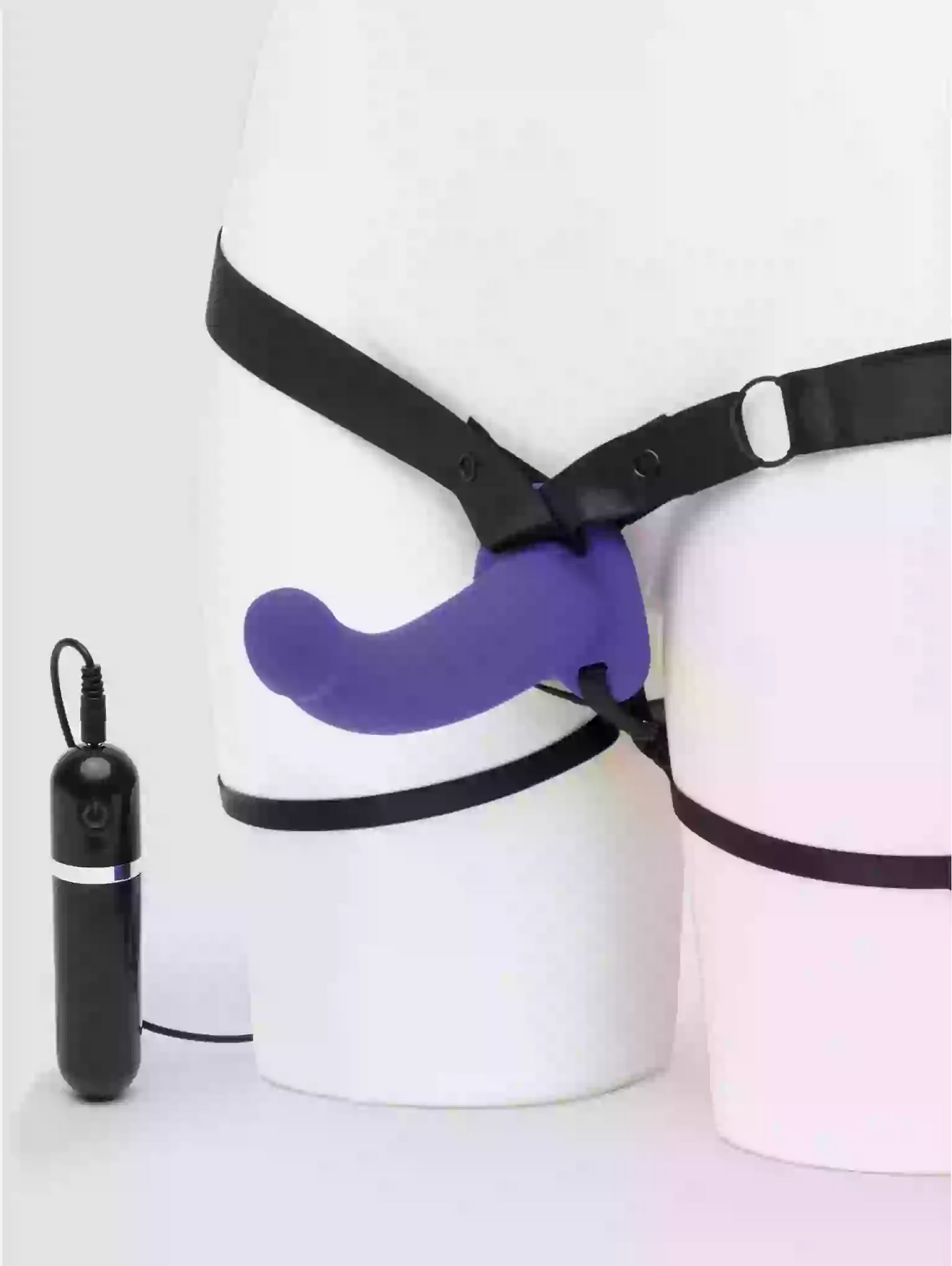 Purple chastity device with black harness on a white background