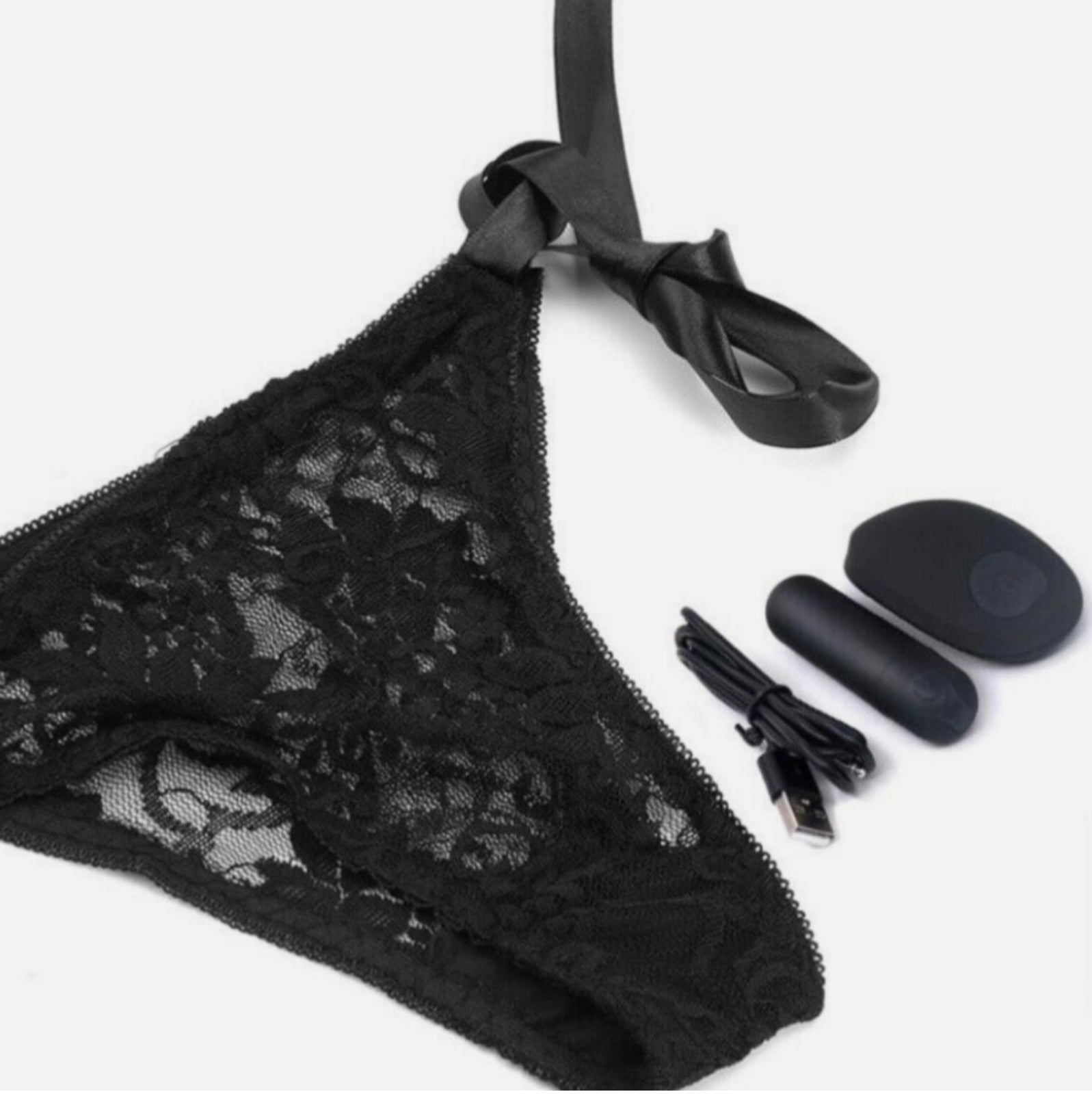 Black lace lingerie set with remote control and USB cable on a white background