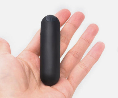 Black cylindrical object held in a hand against a white background