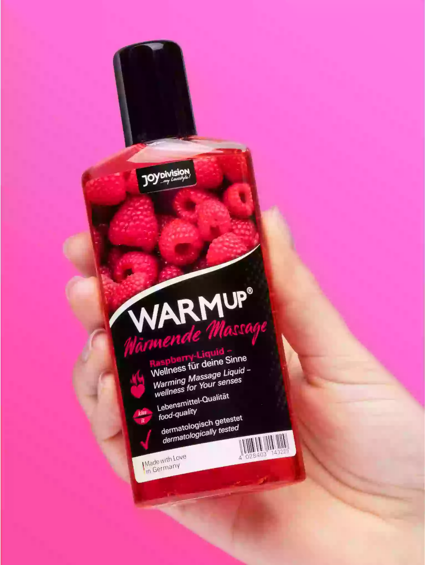 Bottle of Warmup raspberry-flavored lubricant held against a pink background