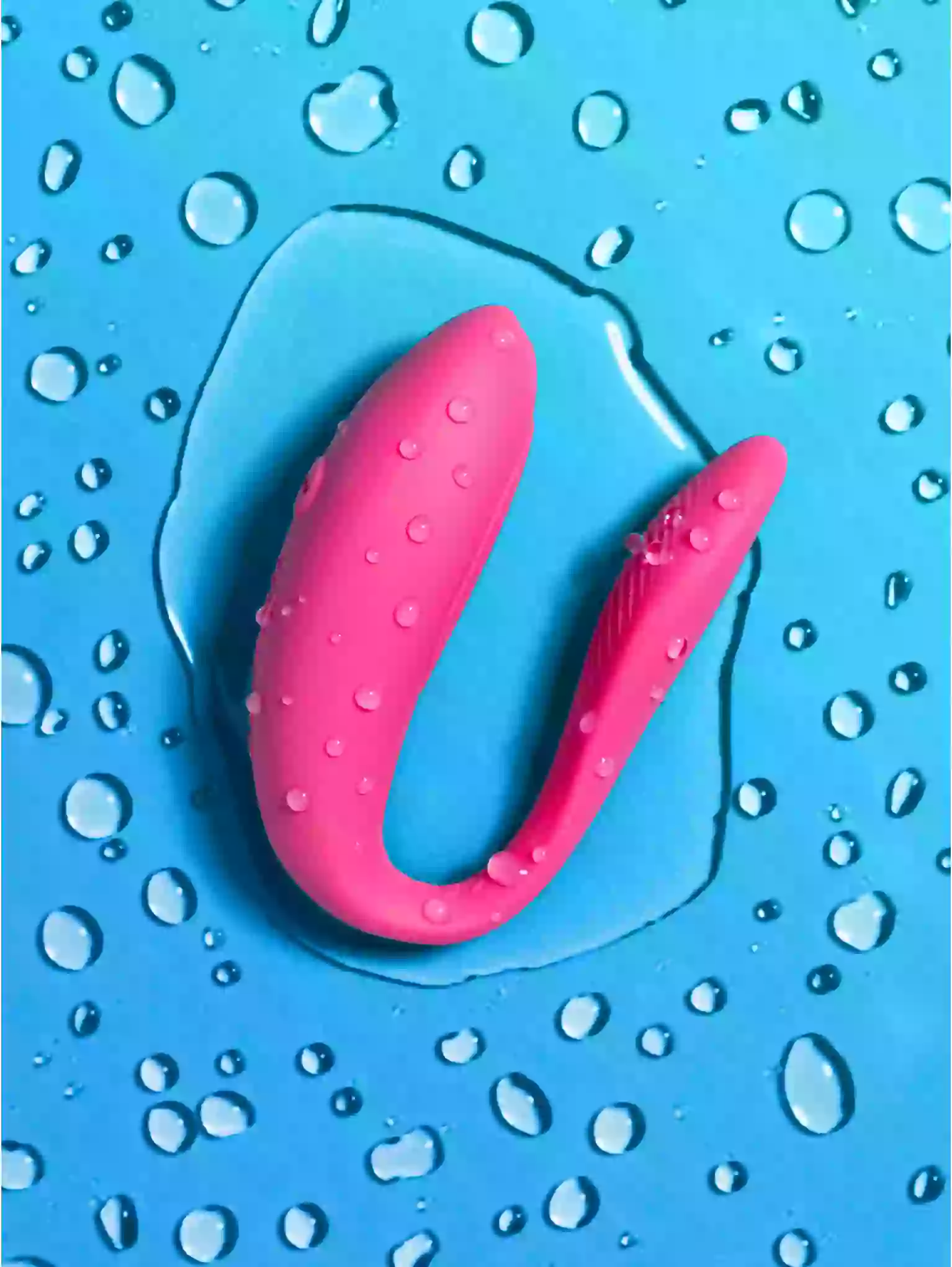 Pink U-shaped object on a blue background with water droplets