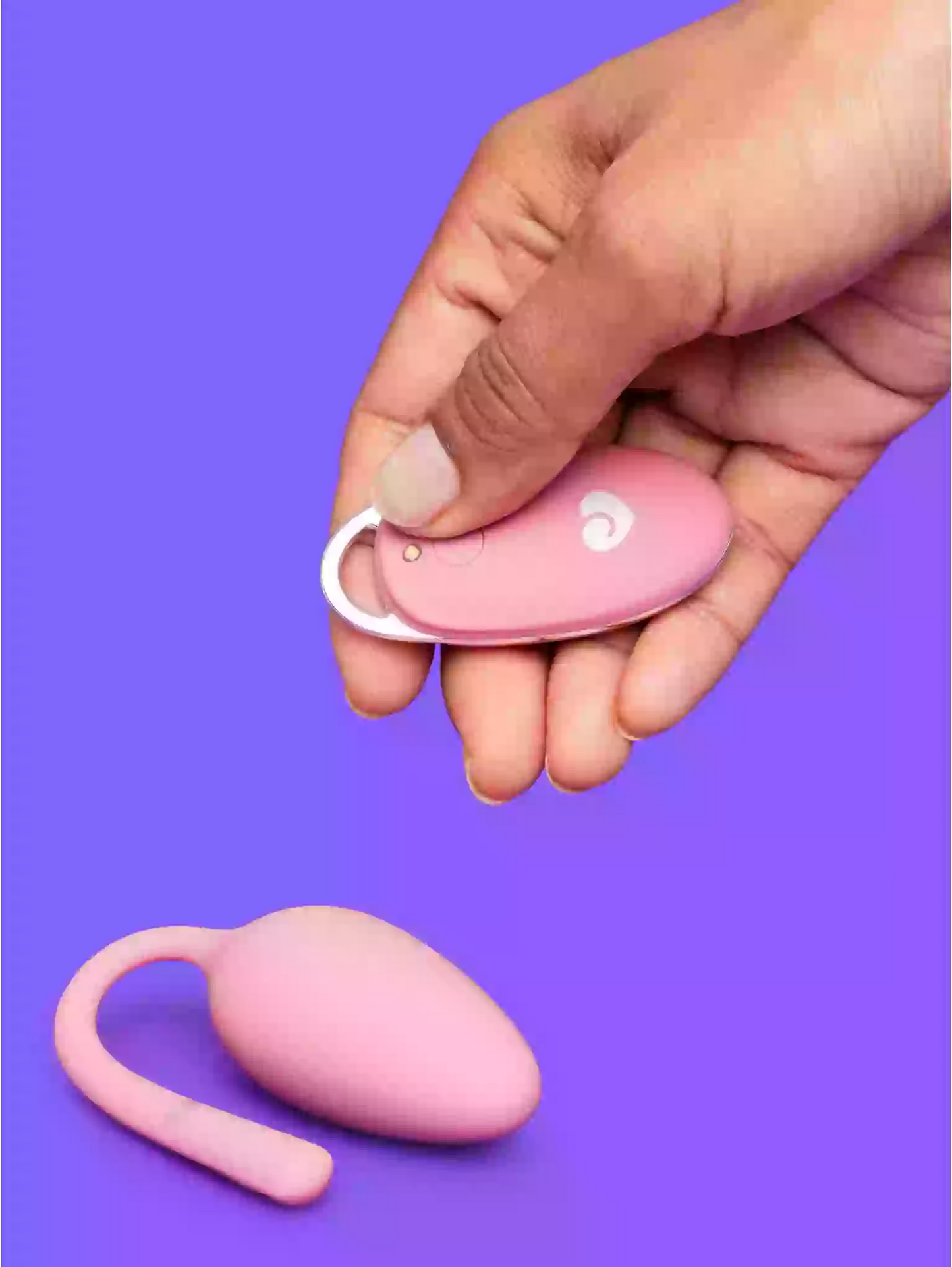 Pink electronic device with a keychain attachment on a purple background